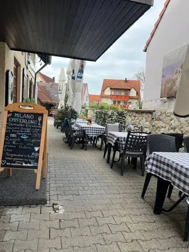 Die Terrasse vor dem Restaurant mit Kreidetafel und karierten Tischdecken